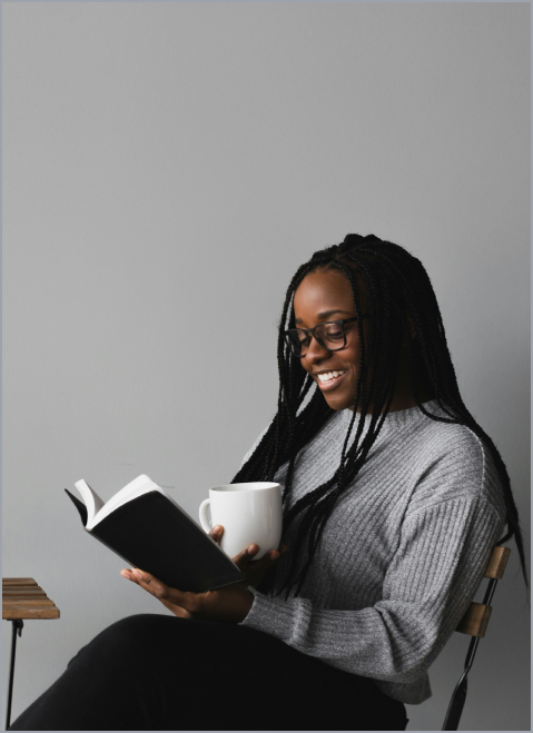African American woman reading at a table.
